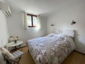 Schlafzimmer mit einem Bett, einem Tisch und einem Fenster in der Unterkunft Charming Villa Saint-Jean-Cap-Ferrat in Saint-Jean-Cap-Ferrat