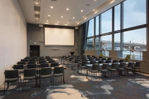 une salle de conférence avec un écran et des rangées de chaises dans l'établissement Scandic Nidelven, à Trondheim