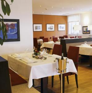 a dining room with tables with white tablecloths at Seeresidenz Alte Post in Seeshaupt