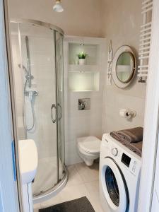 een badkamer met een douche en een wasmachine bij Panorama in Koszalin