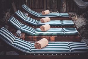 - un groupe de quatre canapés avec serviettes dans l'établissement Aldea San Lam - Oasis Of Tulum, à Tulum
