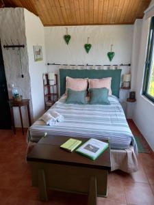 una camera con un letto e un tavolo con un libro di Casinha de campo- Quintinha dos Cavalos- Arruda dos Vinhos ad Arruda dos Vinhos