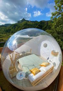 un lit dans un dôme en verre sur une terrasse dans l'établissement La Bolla di Mag, à Saponara Villafranca