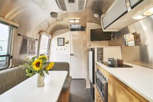a kitchen and dining area of an rv with a vase of sunflower at The Vintages Trailer Resort in Dayton