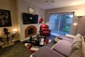 a living room with a couch and a fireplace at Stunning Holiday Home. Free Parking. in Manchester