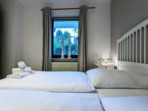 a bedroom with two twin beds and a window at Ferienwohnung Seelboomler in Sankt Peter-Ording