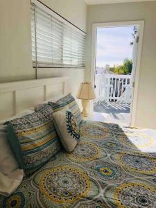 a bedroom with a bed with pillows and a window at Blue Whale Inn San Clemente Jewel Unit D in San Clemente