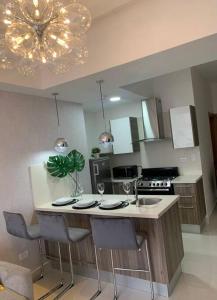 a kitchen with a table with chairs and a chandelier at 1BR Luxury apartment Pool, gym, rooftop Santo Domingo in Santo Domingo