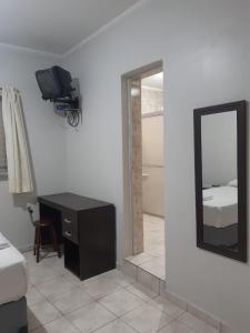 una camera con specchio, scrivania e letto di Apeninos Suites Basicas a San Paolo