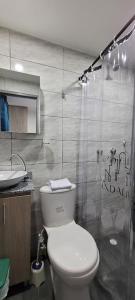 y baño con aseo blanco y lavamanos. en Andaliving Campo Valdes Hospedaje, en Medellín