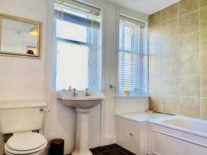 a bathroom with a sink and a toilet and a window at Lovely 2 bed specious flat with indoor fire place in Perth