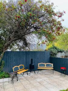 three benches sitting in front of a fence at Lovely 2 bed specious flat with indoor fire place in Perth