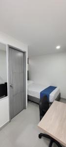 um quarto com duas camas e uma mesa e uma porta em Andaliving Campo Valdes Hospedaje em Medellín