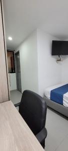 um quarto com uma cadeira, uma cama e uma secretária em Andaliving Campo Valdes Hospedaje em Medellín
