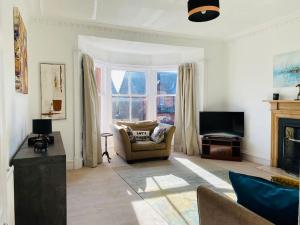 a living room with a couch and a television at Lovely 2 bed specious flat with indoor fire place in Perth