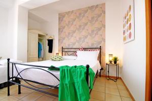 a bedroom with a bed with a green blanket on it at Capo d'Orlando Apartments - Cipria in Capo dʼOrlando