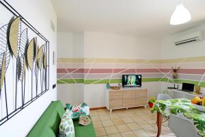 a living room with a green and pink striped wall at Capo d'Orlando Apartments - Cipria in Capo dʼOrlando