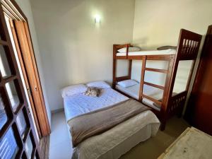 a small room with a bed with a cat laying on it at Casa a 50 M do Mar Para Recarregar as Energias in Bombinhas +44 photos