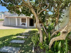 a tree in front of a house with a pathway at Casa a 50 M do Mar Para Recarregar as Energias in Bombinhas