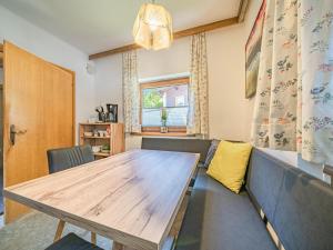 - une salle à manger avec une table en bois et un canapé dans l'établissement Ferienhaus Rieder, à Hopfgarten im Brixental