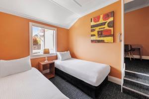 um quarto de hotel com duas camas e uma janela em Hotel Blue & Cottages Katoomba em Katoomba