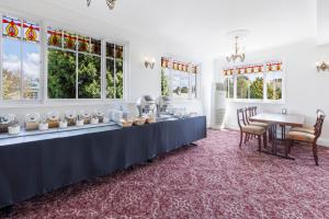 um quarto branco com uma mesa com uma toalha de mesa azul em Hotel Blue & Cottages Katoomba em Katoomba