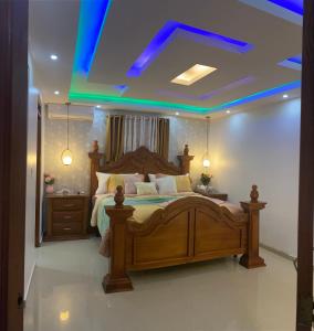 1 dormitorio con cama grande de madera y techo azul en VIP Home en Santiago de los Caballeros