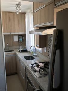 a kitchen with a sink and a stove top oven at Apartamento João e Maria, no coração do Cambuí in Campinas +11 photos