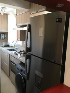 a kitchen with a stainless steel refrigerator in a kitchen at Apartamento João e Maria, no coração do Cambuí in Campinas