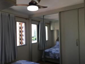 um quarto com uma cama e uma ventoinha de tecto em Apartamento João e Maria, no coração do Cambuí em Campinas