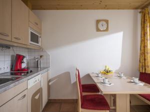 a small kitchen with a table and a clock on the wall at Apartment Erich Brixen in Brixen im Thale