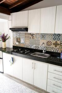 a kitchen with a sink and a stove top oven at Hotel Casa Luna in Cúcuta