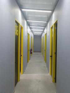 an empty hallway with yellow doors and a hallwayngth at CHECK INN HOSTAL AEROPUERTO GDL in Guadalajara