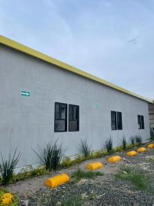 un bâtiment avec des frisbies jaunes devant lui dans l'établissement CHECK INN HOSTAL AEROPUERTO GDL, à Guadalajara