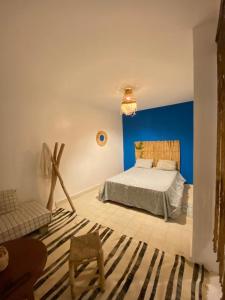 - une chambre avec un lit et un mur bleu dans l'établissement Appartement a ksar SGHIR en face du terminal passagers de Ferry port Tanger Med, à Ksar Sghir