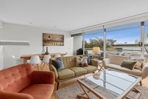 uma sala de estar com sofás e uma mesa de vidro em A Touch Of Class em Lorne