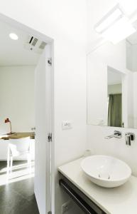 a white bathroom with a sink and a mirror at Genova Porto Antico Boutique Rooms in Genova