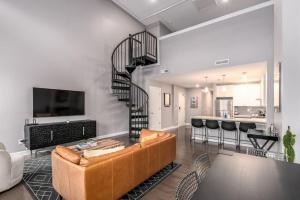 a living room with a couch and a spiral staircase at Soaring 2-Bedroom Parkside Loft Walkable to it All in Cincinnati