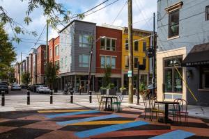 een stadsstraat met tafels en stoelen op een stoep bij Soaring 2-Bedroom Parkside Loft Walkable to it All in Cincinnati