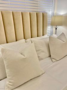 białą kanapę z białymi poduszkami w obiekcie Brand New Modern Flat w mieście Southall