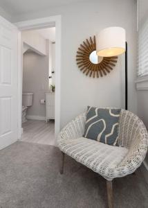 een rieten stoel in een kamer met een spiegel bij Deluxe 4-Bedroom w Huge Deck 3-Min to Downtown in Cincinnati