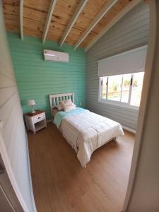 a bedroom with a bed with a green wall at Las Igoa in Carmelo