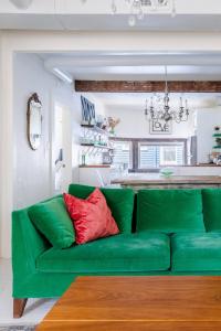 a green couch in a living room with a kitchen at Boutique Apartment in 1905 Victorian Home - Plaza - Westport in Kansas City