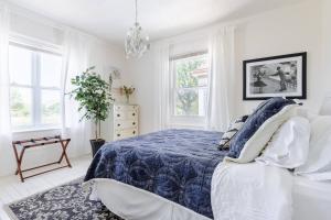 a white bedroom with a bed and a chandelier at Boutique Apartment in 1905 Victorian Home - Plaza - Westport in Kansas City