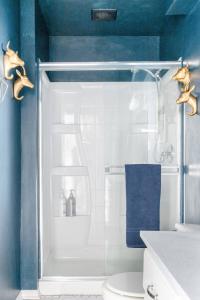 a blue bathroom with a shower with a toilet at Boutique Apartment in 1905 Victorian Home - Plaza - Westport in Kansas City