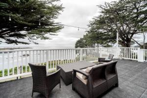 eine Terrasse mit einem Tisch, Stühlen und Meerblick in der Unterkunft Agate Cove Inn in Mendocino