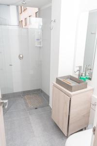 a white bathroom with a sink and a shower at Apartamento Loft Edificio Soho 906 in Armenia