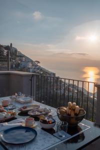 einen Tisch mit Tellern aus Essen auf einem Balkon in der Unterkunft Lena Magda B&B in Furore