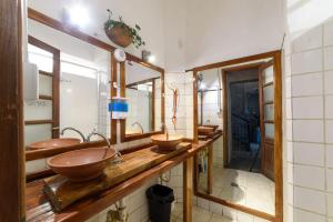 a bathroom with three sinks and two mirrors at Rupestre Hostel in Córdoba