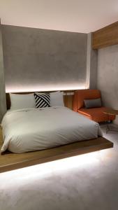- une chambre avec un lit et une chaise orange dans l'établissement 泥house, à Luodong